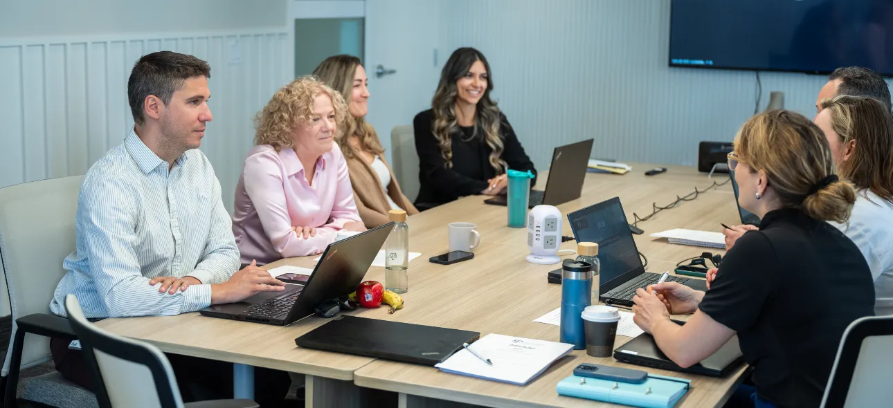 Collègues assis autour d'une grande table pour une réunion de travail.