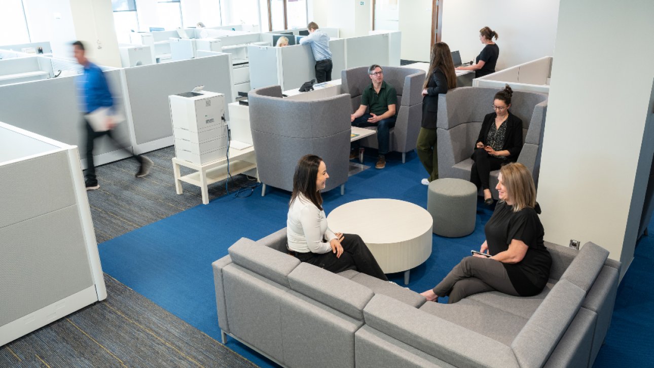 Des collègues sont assis, discutent ou marchent dans les bureaux de Québec du Protecteur du citoyen.