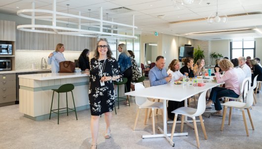 De nombreux collègues mangent et marchent dans la cafétéria.