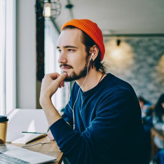 Étudiant assis dans un endroit public avec son ordinateur et un café